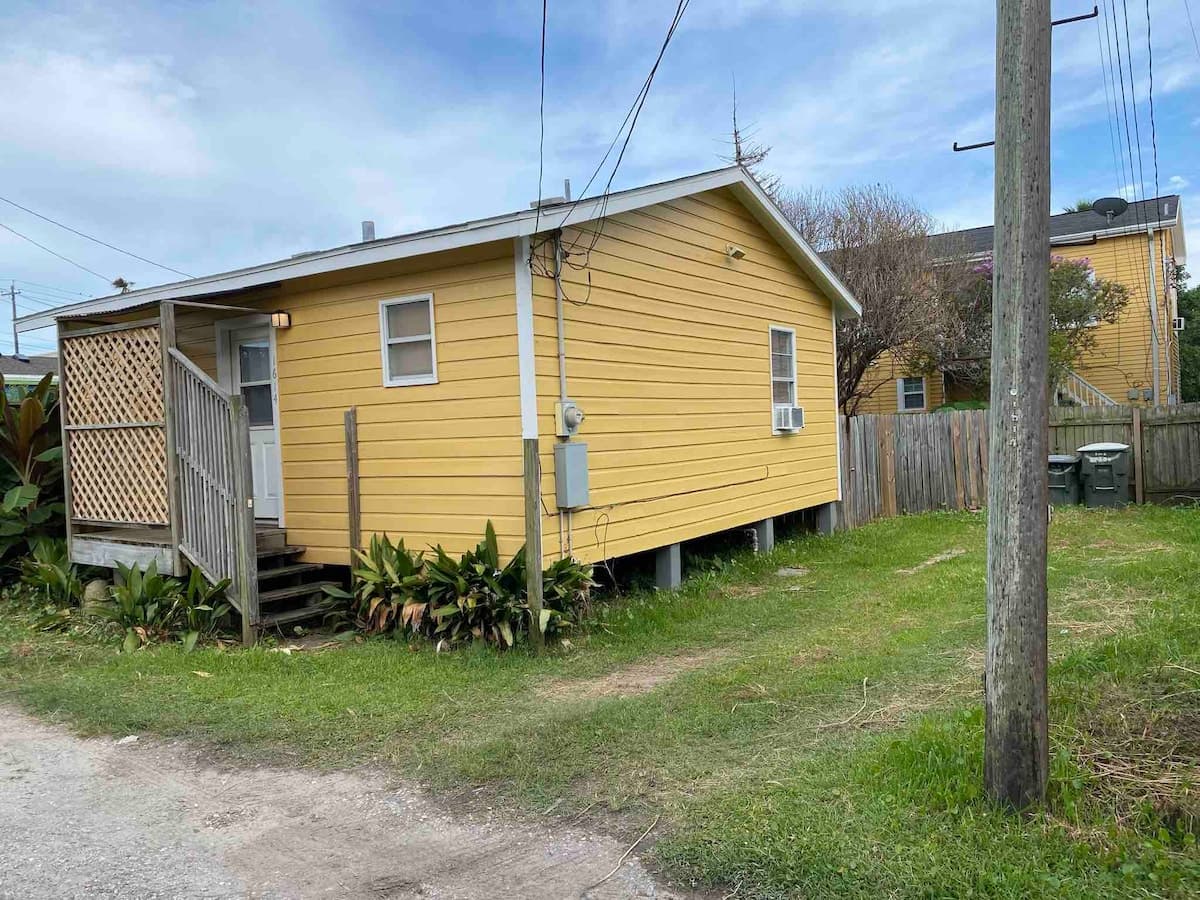 Backyard has private parking and access, with a small deck with outdoor furniture in front of cottage for relaxing after a long day at the beach.